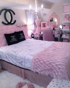 a bedroom decorated in pink and black with chandeliers on the wall, bedding, dressers and mirror