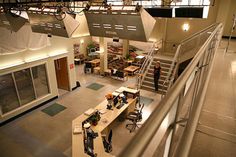 an overhead view of people working at desks in a large room with lots of windows