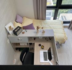 an aerial view of a bedroom with a bed, desk and laptop