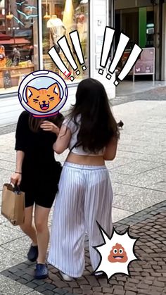 two women are walking down the street talking to each other and one has an orange cat on her head