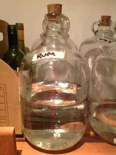 two empty glass bottles sitting on top of a wooden table next to boxes and corkscrews