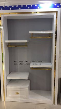 an empty white shelf with gold handles and shelves on each side, in a store