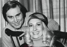 the man and woman are posing for a black and white photo with their hair pulled back