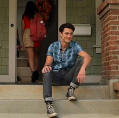 a man sitting on the steps in front of a house