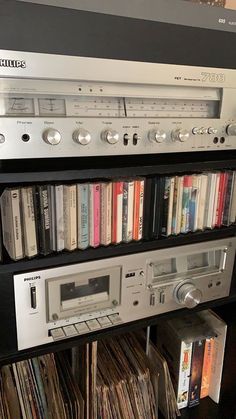 an old stereo system sitting on top of a shelf filled with cd's and cds