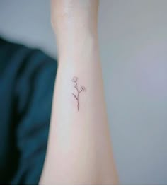 a small flower tattoo on the wrist