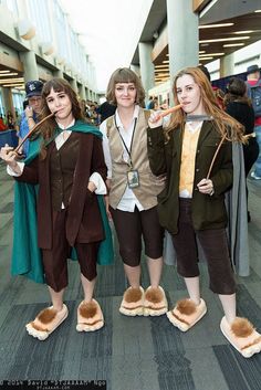 three young women dressed in costume standing next to each other on the floor at an airport