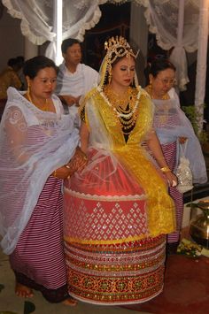 a woman in a yellow and red dress sitting on top of a large round object