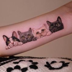 a woman's arm with three cats on it