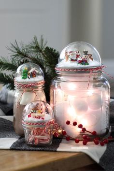 two glass jars with christmas decorations on them, one is filled with lights and the other has