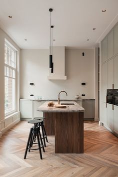 a kitchen with two stools next to an island