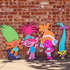 three cut outs of cartoon characters on the side of a brick wall in front of a building