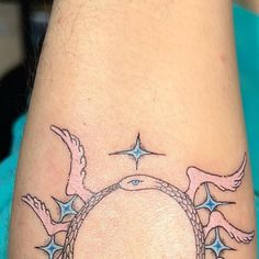 a woman's arm with a bird and star tattoo on it