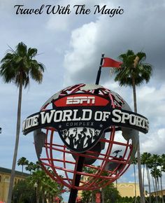 a sign for the world of sports complex with palm trees in the background and text that reads travel with the magic