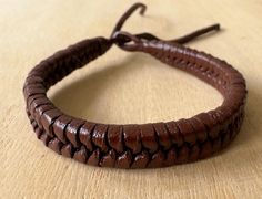 a close up of a leather bracelet on a table