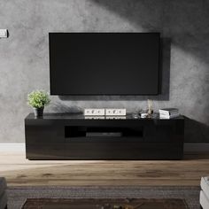 an entertainment center with a flat screen tv mounted on it's side, in front of a gray wall