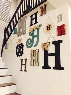 there are many letters on the wall above the stair case and handrails that have been decorated with bows