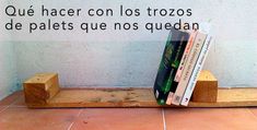 three books sitting on top of wooden blocks in front of a wall with spanish text