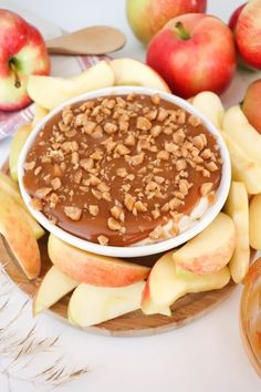 an apple and peanut butter dip surrounded by apples