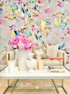 a living room with flowers on the coffee table and wall paper behind it that says cocktails