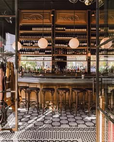 an empty bar with stools and bottles on the shelves