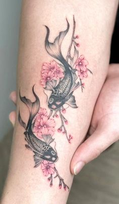 a woman's leg with a tattoo on it and two fish in the water