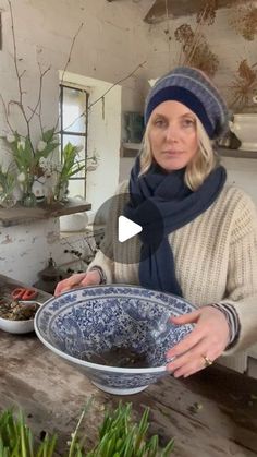 a woman is holding a bowl with plants in it and she is looking at the camera