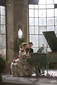 a man and woman sitting at a piano