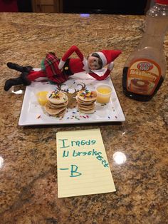 an elf laying on top of a counter next to some food and drink bottles with writing on it