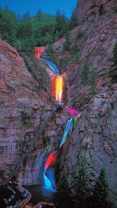 the waterfall is lit up with colorful lights