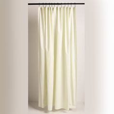 a white shower curtain hanging on a metal rod