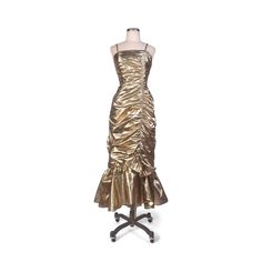 Vintage 1980s hourglass metallic gold party dress/prom dress. This has spaghetti shoulder straps and the dress is fitted down the length of the body, with gathering up the left side.  The fabric flares out at the bottom with a bow at the bottom of the vertical gathered seam. The skirt is slightly longer in the back than in the front. This is made of a lightweight, almost sheer metallic gold fabric.  It's slightly gauzy and stiff, and gorgeous. ★Closures: Nylon zipper up the back. ★Lining: Fully lined with sheer black fabric except for the fishtail hem. There is also boning up the front left side of the bodice and up either side. ★Label: "New Leaf by Samir," "Dry Clean Only...Made in USA...Size 11/12..."" (Please ignore the vintage sizing and refer to the measurements). ★Condition: Very goo Prom Dress 80s, Party Dress Gold, Dress Fishtail, Prom Dress Gold, Gold Prom Dress, 80s Party Dress, Gold Party Dress, Vintage 80s Dress, 80s Prom Dress