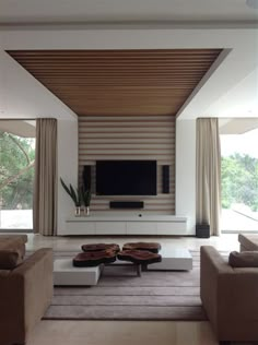 a living room with two couches and a flat screen tv mounted on the wall