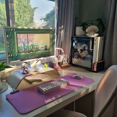 a computer desk with a keyboard, mouse and monitor on it in front of a window