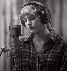 a woman with headphones on singing into a microphone