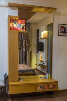 a mirror sitting on top of a wooden dresser next to a bed in a bedroom