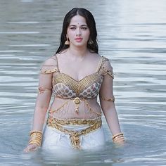 a woman in a body of water with chains around her waist