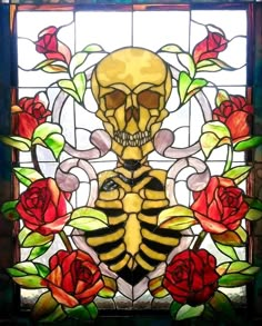 a stained glass window with a skeleton and roses