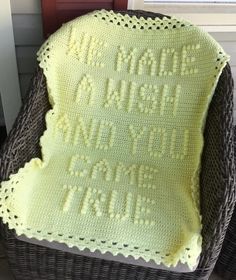 a crocheted blanket sitting on top of a wicker chair