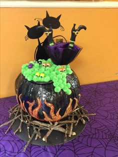 a halloween decoration on top of a table with purple and green decorations in the shape of pumpkins