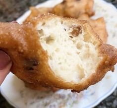 a person is holding up a piece of fried food