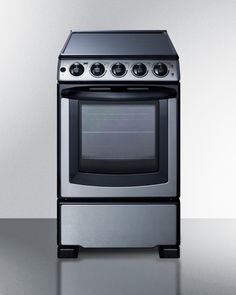 a silver stove top oven sitting on top of a metal counter next to a white wall