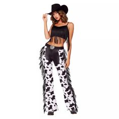 a woman wearing cow print pants and a black top with fringes on it, posing for