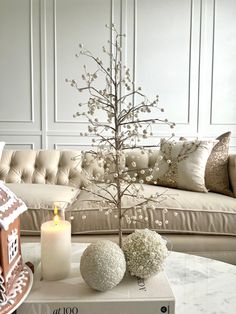 a living room filled with furniture and a christmas tree on top of a coffee table