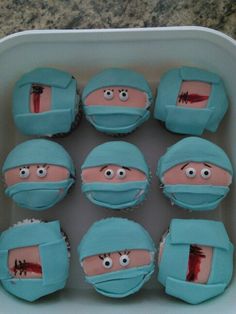 twelve cupcakes in the shape of surgeon's faces with blood on them