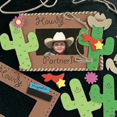 a photo frame with cactus, cowboy hats and name tags attached to the back of it