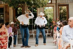 two men in cowboy hats standing next to each other at a wedding ceremony with people watching