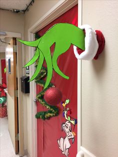 the grinch door is decorated with christmas decorations and stockings hanging from it's hooks