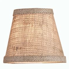 a lamp shade that is on top of a white table cloth light fixture with an old - fashioned look