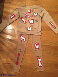 a child's pajama set with dogs and bones on the side, sitting on a wooden floor